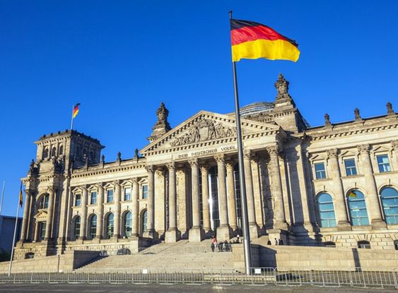 Almanya'nın başkenti Berlin'de bulunan tarihi Reichstag binası ve dalgalanan Almanya bayrağı.